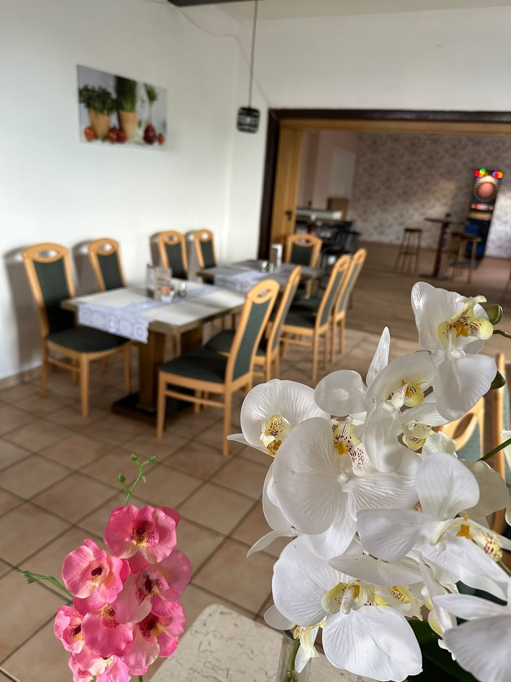Festlich eingedeckte Tische mit Orchideen für eine Feier im Restaurant Pizzeria Aroma