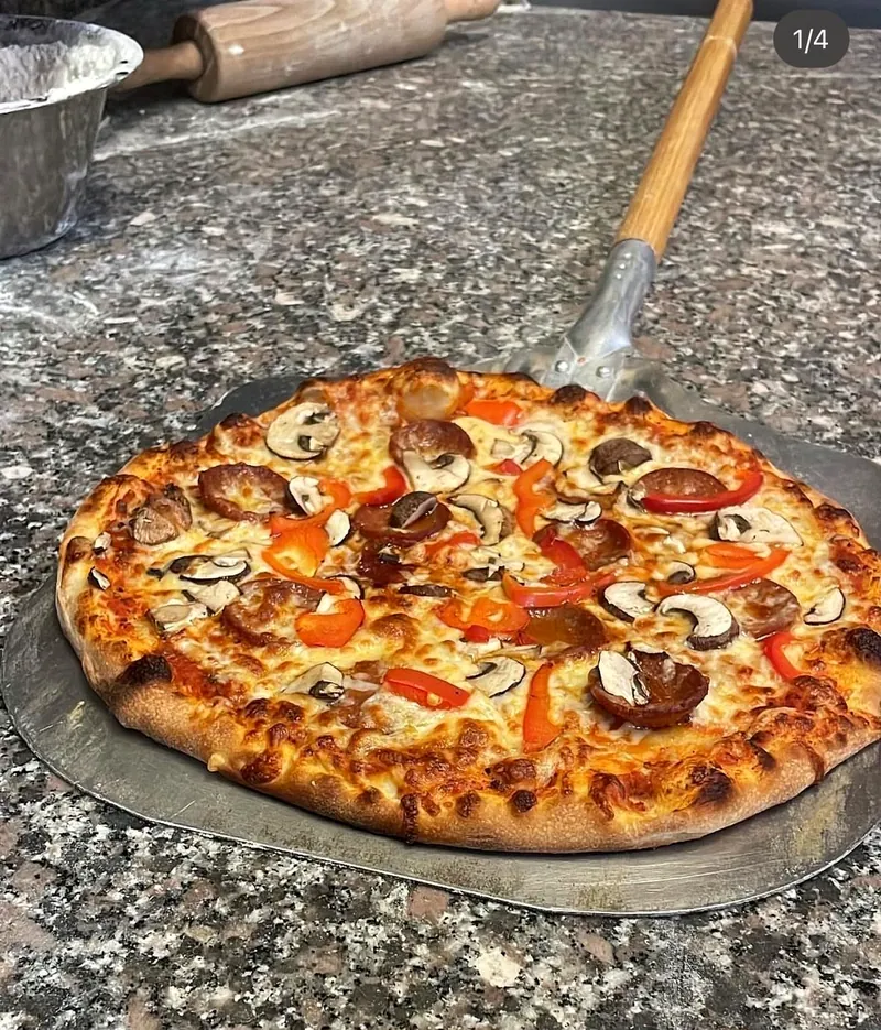 Pizza mit Champignons und Salami auf dem Pizzaschieber