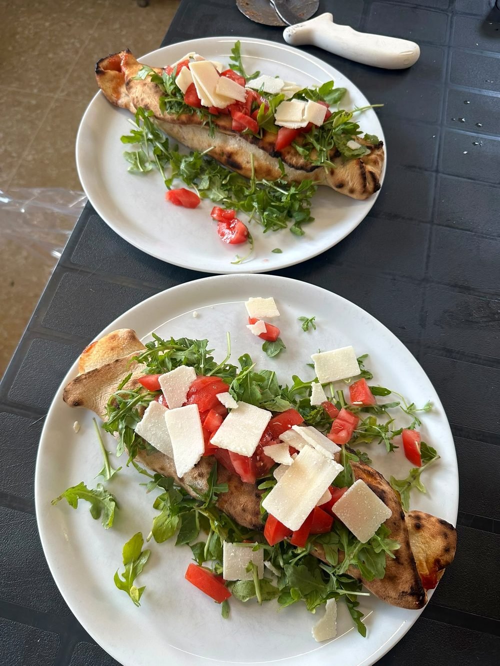 Zwei frische Salatteller mit Tomaten, Rucola und Käse